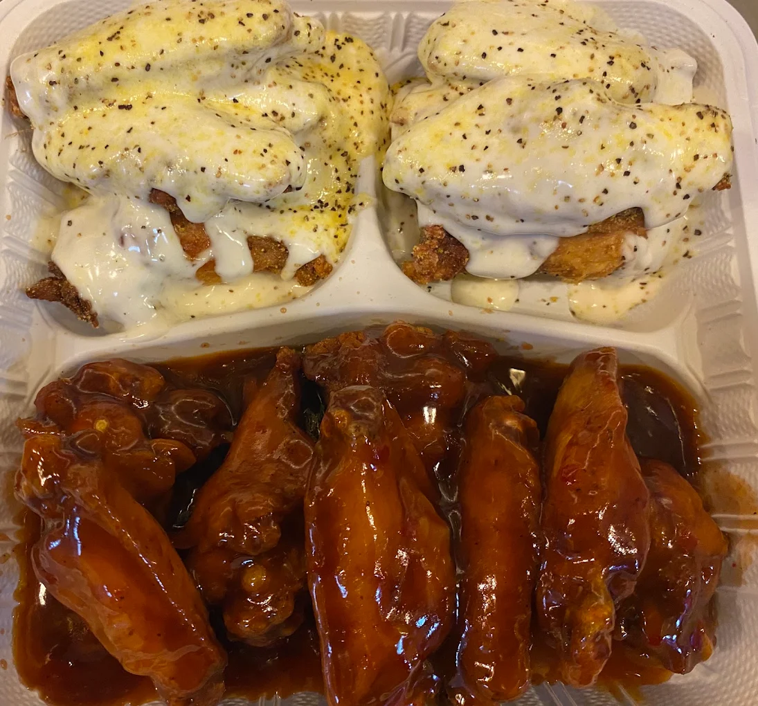 Chicken smothered in white gravy and saucy wingz